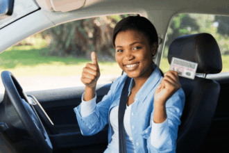 Happy young learner's license recipient proudly holding her driver's license.